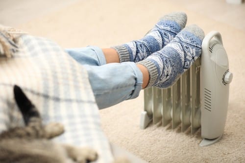 Chauffagiste Trélazé - pieds posés sur un mini chauffage