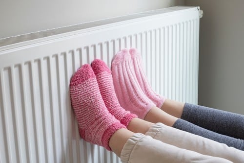 Chauffagiste Val-de-Reuil - les bons artisans - pieds contre un radiateur