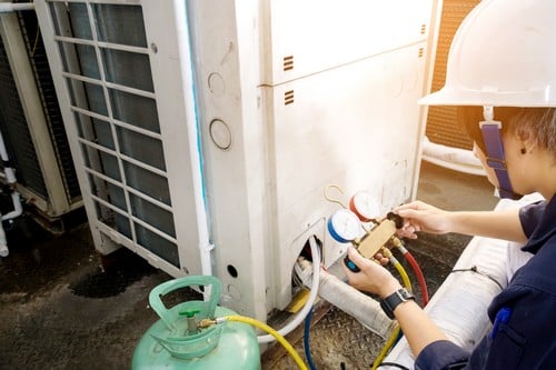 Climatisation Boulogne-Billancourt - homme qui règle un climatiseur