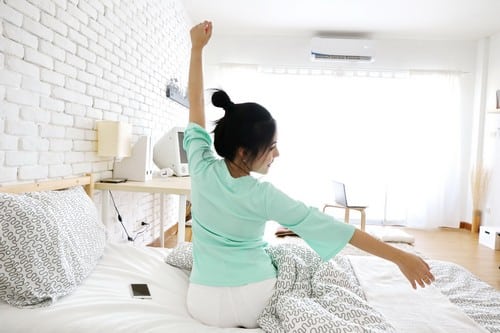 Climatisation Meudon - femme qui s'étire dans une pièce climatisée