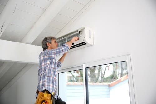 Climatisation Paris 20 - homme qui installe un climatiseur au plafond