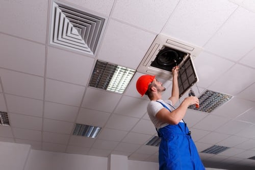 Climatisation Paris 9 - homme qui installe un climatiseur au plafond