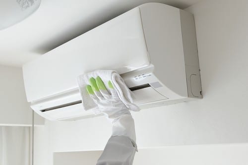 Climatisation Rueil-Malmaison - main d'un homme qui nettoie un climatiseur au plafond