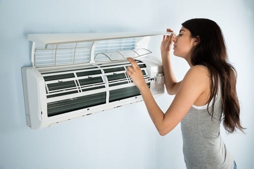 Climatisation Rueil-Malmaison - femme qui règle un climatiseur