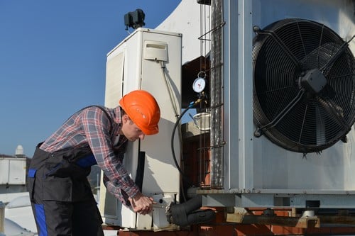 Climatisation Thiais - homme qui règle un climatiseur en extérieur