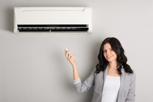 Climatisation Vigneux-sur-Seine - femme qui tient une télécommande pour régler climatiseur