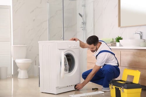 Plombier Mouans Sartoux - homme qui règle une machine à laver