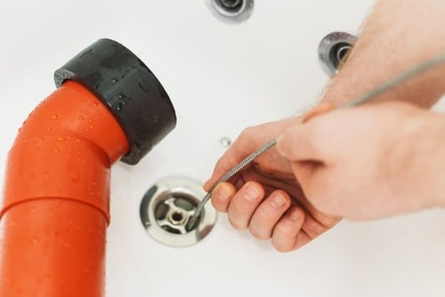 Plombier Valenton - mains d'un homme qui débouche un évier