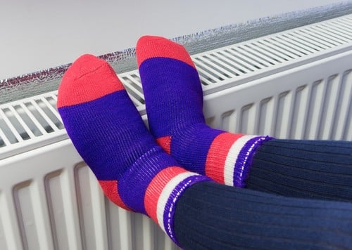chauffagiste Ambérieu-en-Bugey - Se réchauffer les pieds sur un radiateur