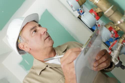 chauffagiste Lieusaint - un artisan inspecte une installation de chauffage