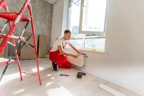 chauffagiste Provins - un plombier chauffagiste nstalle un système de chauffage dans une maison en construction