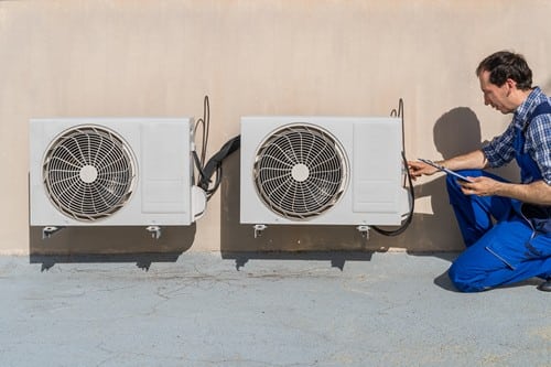climatisation Bondy - un artisan frigoriste installe les unités extérieures en hauteur