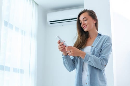 climatisation Eaubonne - une femme allume son système de refroidissement