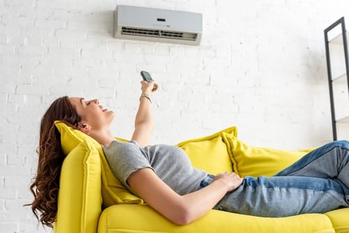 climatisation Franconville - une femme allongée sous une climatisation