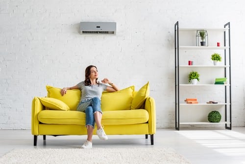 climatisation Garges-lès-Gonesse - une femme assise sur un canapé sous sa clim