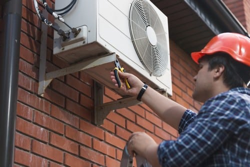 climatisation Gennevilliers - homme qui règle un climatiseur en extérieur