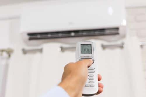 climatisation Pontoise - un homme utilise une télécommande pour allumer sa climatisation