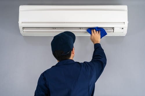 climatisation Pontoise - un frigoriste nettoie une climatisation