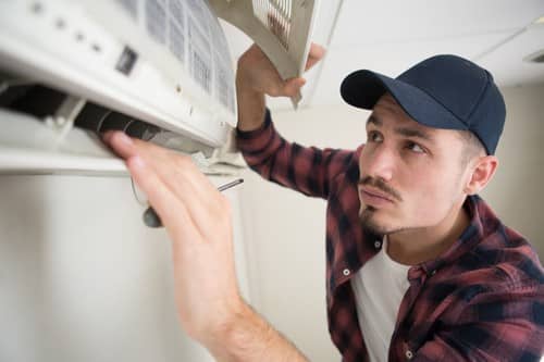 climatisation Roissy-en-Brie - un artisan frigorite entretient un climatiseur