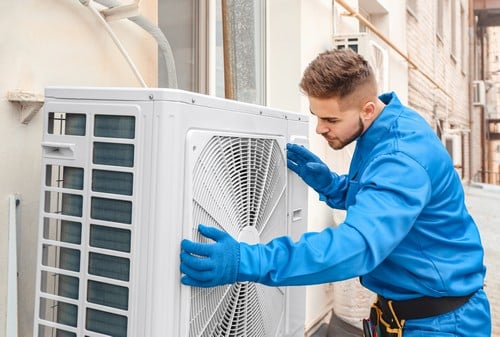 climatisation Saint-Denis - un artisan installe une unité extérieure