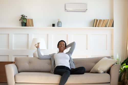 climatisation Saint-Denis - une femme profite de sa climatisation, assise sur son canapé