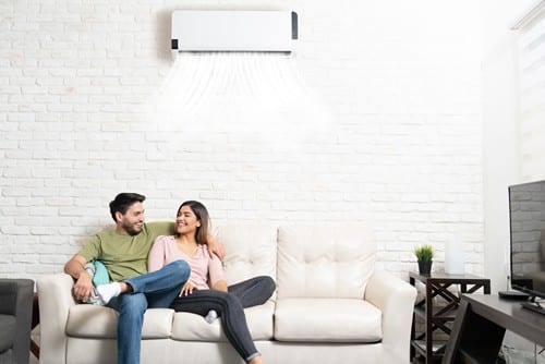 climatisation Saint-Ouen - un couple est installé sur leur canapé sous la climatisation