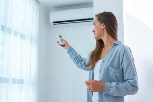 climatisation Saint-Ouen-l'Aumône - une femme allume sa climatisation