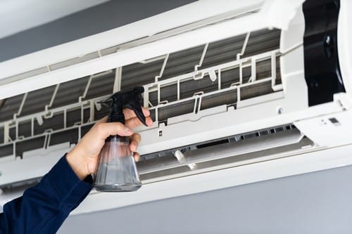 climatisation Villiers-sur-Marne - une personne nettoie un climatiseur