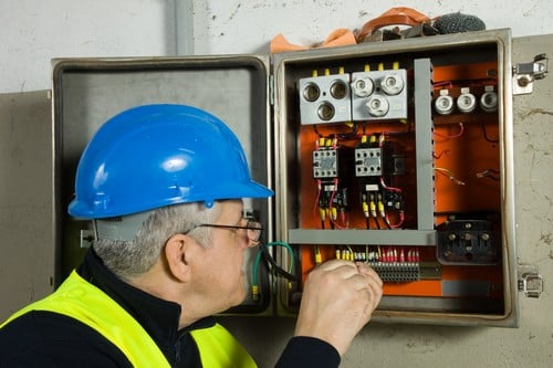 électricien Chevigny-Saint-Sauveur - un artisan électricien inspecte une armoire électrique