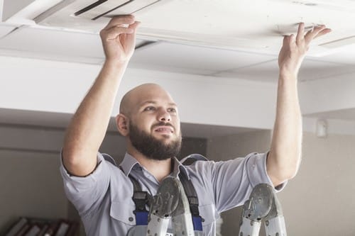 Climatisation Ramonville-Saint-Agne - homme qui règle un climatiseur au plafond