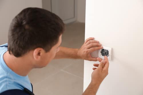 Electricien Château-Gontier - homme qui installe une prise murale