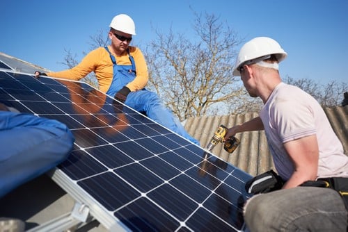 Electricien Guérande - hommes qui installent des panneaux solaires sur un toit