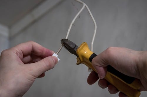 Electricien Jouy-le-Moutier - mains qui règlent un câble électrique