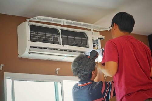 Electricien Le Raincy - hommes qui règlent un appareil électriques au plafond