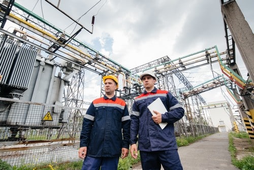 Electricien Lieusaint - deux hommes devant une centrale électrique