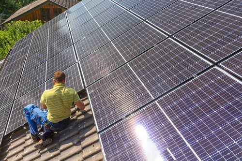 Electricien Provins - homme qui installe des panneaux solaires