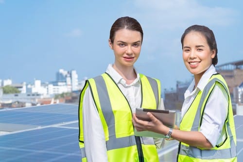 Electricien Saint-Fargeau-Ponthierry - deux femmes devant des panneaux solaires sur un toit