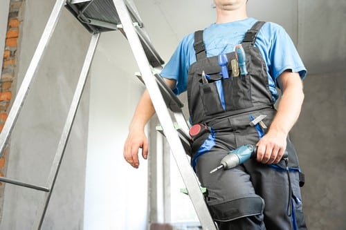 Electricien Vauréal - homme qui installe un appareil électrique au plafond