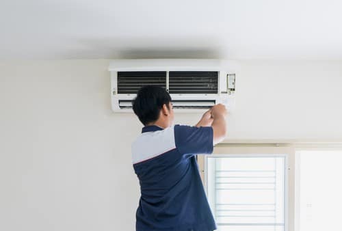 Electricien Villenave-d'Ornon - homme qui installe un climatiseur