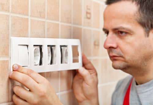 Electricien Viroflay - homme qui installe des prises murales