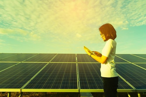 Electricien Voisins-le-Bretonneux - femme devant des panneaux solaires