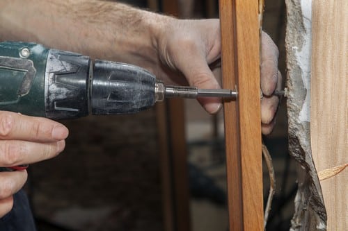 Serrurier Vauréal - mains d'un homme qui règle une porte