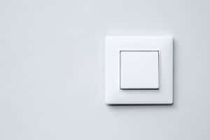 Un interrupteur va et vient blanc sur un mur blanc