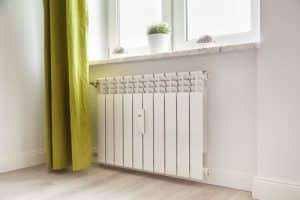 Un radiateur bain d'huile à côté d'un rideau