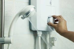 une personne règle son chauffe eau électrique instantané