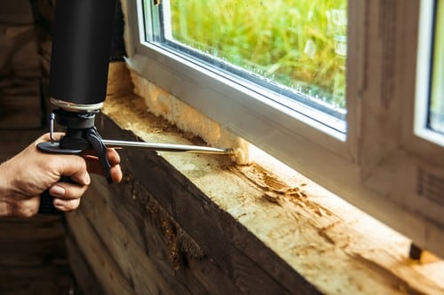 vitrier Roquefort-la-Bédoule - un artisan finit l'isolation d'une fenêtre en PVC