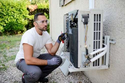 Climatisation Bouc-Bel-Air - homme qui règle un climatiseur en extérieur