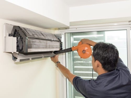 Climatisation Crosne - homme qui nettoie un climatiseur au plafond
