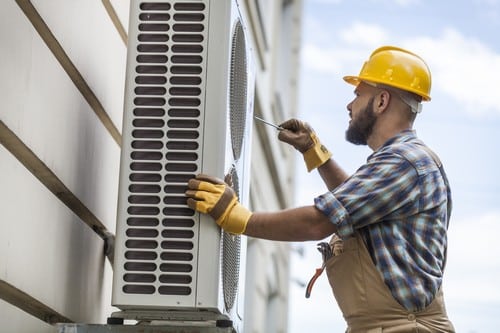 Climatisation Dammartin-en-Goele - les bons artisans - artisan en intervention sur une unité extérieure de climatisation