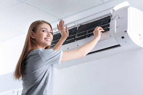 Climatisation Fleury-Merogis - femme qui met ses mains devant un climatiseur